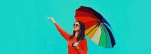 Autumn Portrait Of Happy Smiling Young Woman Holding Colorful Umbrella Wearing Red Knitted Sweater On Blue Background