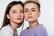young and pretty lesbian couple with makeup isolated on grey.