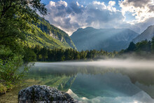 Fog Above The The Lake Bluntausee In Front Of Mountains Of The Alps Mountains In Salzbuger Land, Austria, Europe