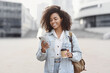 © kite_rin - Young beautiful woman using smartphone in city. Smiling student girl texting on her mobile phone. Coffee break. Modern lifestyle, connection, business concept