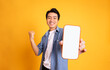 © Q88 - image of asian man holding phone, isolated on yellow background