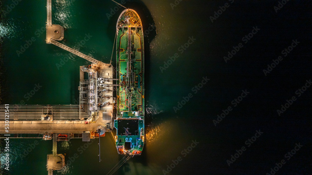 Aerial top view oil tanker ship at terminal industrial port at night ...