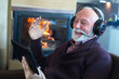 © Solid photos - Senior man on the video call sitting in front of the fireplace in winter