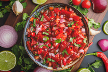 Top View Of Fresh Salsa Made With Homegrown Ingredients Of Tomatoes, Red Onions, Garlic, Chili Peppers, Cilantro And Lime