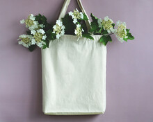 A White Cloth Bag With Viburnum Inflorescences On A Purple Background. A Concept Without Plastic.