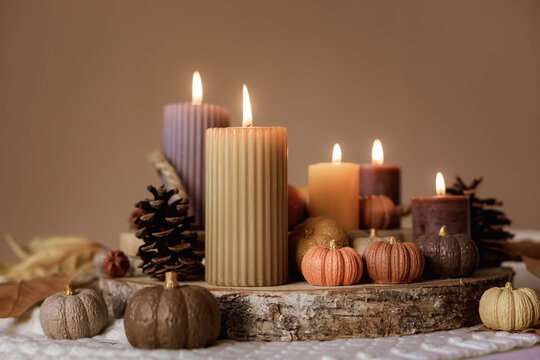 Autumn table decoration. Interior decor for fall holidays with handmade pumpkins and candles. Holiday greeting card