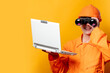  worker in helmet and orange overalls with laptop computer and binocular