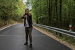 © Lilu - a young man is walking near the road and in the forest