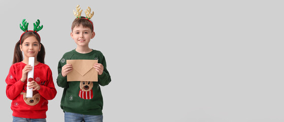 Poster - Funny little children with reindeer horns and letters to Santa on light background with space for text