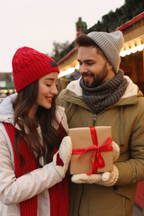 Lovely couple with Christmas present at winter fair