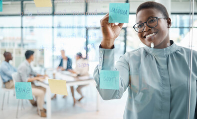 Black woman, post it writing and schedule planning in global business office, marketing startup and creative company. Smile, happy and teamwork leader in meeting with training timeline notes on wall