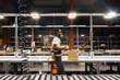 © sata_production - African factory worker delivering box at the storage