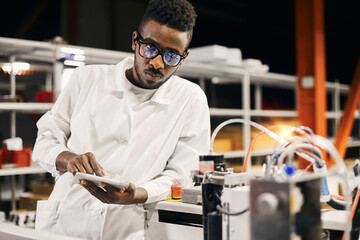 Wall Mural - african engineer programming equipment with tablet at factory