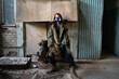 Post apocalyptic female survivor in gas mask sitting in a ruined building. Environmental disaster. Environmental pollution, ecological disaster, nuclear war, post apocalypse