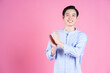 Portrait of young Asian man on pink background