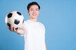 © Timeimage - Young Asian man holding ball on background