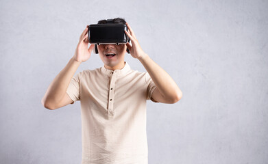 Sticker - Young Asian man using VR glasses on background