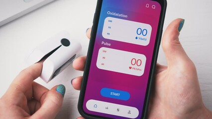 Woman checks oxygen saturation on his smartphone. Pulse oximeter app for mobile phone.
