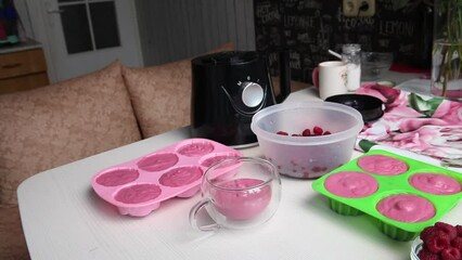 Wall Mural - Silicone molds with cottage cheese and raspberry soufflé. The woman fixes her mug. The camera moves on a slider. Overall plan.