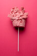Vertical image of homemade pink candy floss on stick, on pink background with copy space