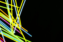 Image Of Vibrant Stack Of Neon Glow Sticks Scattered Over Black Background With Copy Space