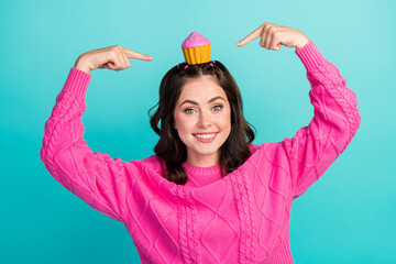 Sticker - Photo of young attractive cute woman wear pink knitted sweater directing fingers head muffin delicious new menu isolated on cyan color background