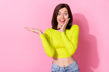 Wall Mural - portrait of crazy impressed lady arm palm touch cheek hold empty space offer isolated on pink color 