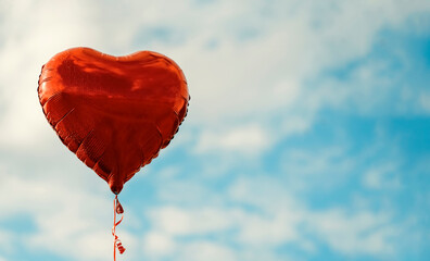 red balloon in the shape of a heart against the blue sky Space for text Holiday card, Happy Valentine's day concept Love in air