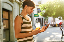 Man With Juice Using Smartphone On Street