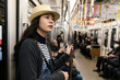 © PR Image Factory - beautiful Asian Japanese girl wearing hat traveling by taking subway in nara-shi japan. she holds the pole and looks at space while standing in the train car.
