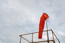 An Orange Windsock On Rooftop Of The Industrial Plant, It Using To Identify Windy Speed And Direction. Industrial Safety Equipment Object Photo.