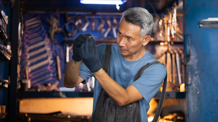 Wall Mural - Portrait senior asian male mechanic engineering working on tools box background. Repair specialist, technical maintenance. Small business owner.