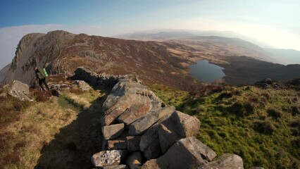 Wall Mural - A backpacking man hiking down into the Rhinogydd mountains of North Wales Snowdonia UK