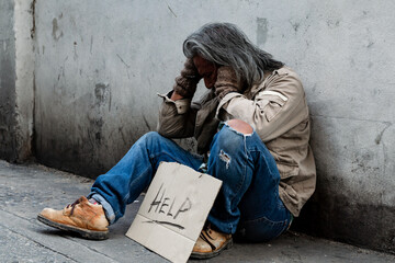 Wall Mural - Long-haired old man, Homeless man in a shabby-dressed street, was delighted that he had received money from a yellow purse donor on the floor. waiting for help from others