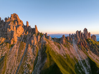Fototapete - Sunrise in the Dolomites mountains with fog and mist rolling around the peaks. Hiking path leading to the hills. 
