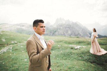 Wall Mural - Groom smoking cigarette. Bride on the background