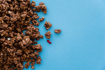 Wall Mural - top view of crunchy and sweet oat granola isolated on blue.