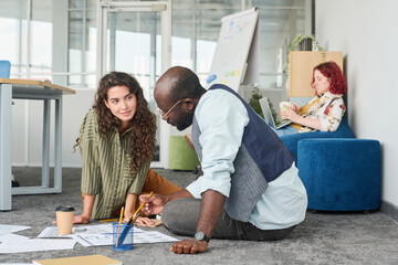 Aufkleber - Young businesswoman looking at male confident pointing at document with financial data and listening to his explanation at meeting