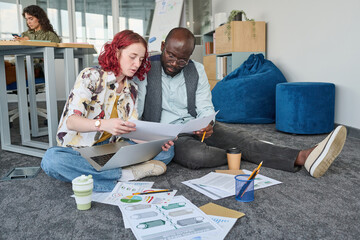 Aufkleber - Young confident businesswoman showing financial document to African American male colleague and explaining data to him