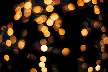 Yellow abstract bokeh made from Christmas lights on black isolated background. Holiday concept, blur bokeh, overlay for your images.