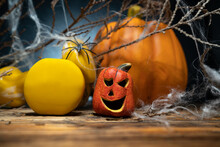 Two Yellow Gym Dumbbells, Small Ceramic Halloween Jack O Lantern Figurine And Autumn Pumpkin In Background, Covered With Spider Web. Healthy Fitness Lifestyle Fall Composition.