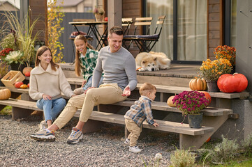 Happy family of four resting on the veranda