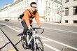 © muse studio - A male cyclist rides a bicycle in the city to work.