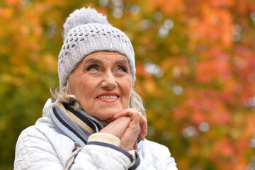 Poster - Senior woman walking in the park in autumn