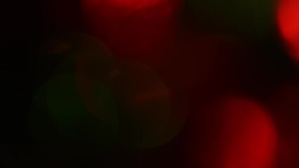 Wall Mural - Christmas bokeh motion. Red and Green defocused circles shimmer, shine and sparkle. Lens effect. Can be used as background, overlay or screen. New Year's lights.