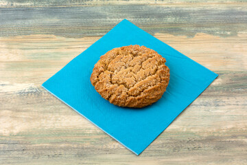 Canvas Print - One baked chewy ginger cookie on blue napkin on table