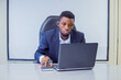 © Ifiok - A man in a suit in the office with a laptop