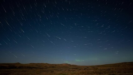 Wall Mural - star trail time lapse with stars above a peaceful prairie setting and aurora flashing along the hori