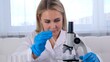 © Евгения Медведева - professional scientist takes a sample for a medical experiment. A research chemist works in a laboratory with a micropipette and a microscope