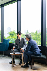 Poster - ロビーで会話するエグゼクティブ男性と若手社員